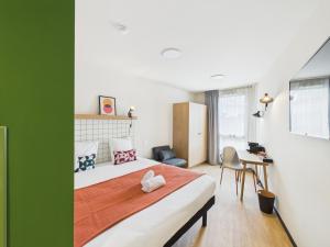 Un dormitorio con una cama y una pared verde. en Hife Vélizy, en Vélizy-Villacoublay