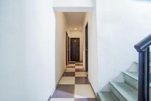 a hallway with stairs and a black door at Super Hotel O Hingna Road Near Rachana Metro Station in Nagpur