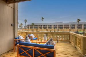 Un balcón con sillas y mesas en un edificio. en Fisherman Friend! - Coastal Condo - Views Await!, en Fulton