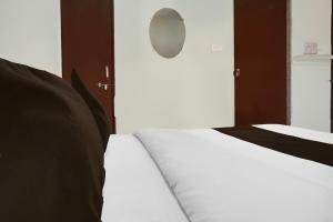 a bedroom with two beds with white sheets and a mirror at Super Collection O Talwade in Pune