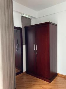 a large wooden cabinet in a room with wooden floors at Galway Green - Lake View Luxury Apartment, Nuwara Eliya Sri Lanka in Nuwara Eliya +28 photos