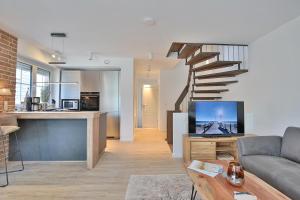 a living room with a couch and a staircase at Haus Oberdeck 2 in Scharbeutz