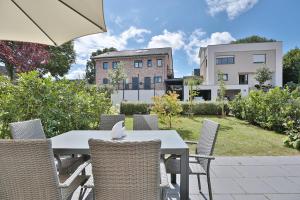 a table with chairs and an umbrella in a garden at Haus Oberdeck 2 in Scharbeutz