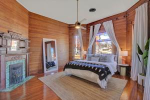 ein Schlafzimmer mit einem Bett und einem Kamin in der Unterkunft Gorgeous Home 1 Blk from Main with Hot Tub & Fire Pit! in Fredericksburg