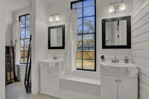 ein weißes Badezimmer mit zwei Waschbecken und zwei Spiegeln in der Unterkunft Gorgeous Home 1 Blk from Main with Hot Tub & Fire Pit! in Fredericksburg + 32 Fotos