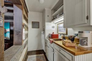 a kitchen with white cabinets and a counter with a sink at Town Creek Cabin Walk to Main St in Fredericksburg