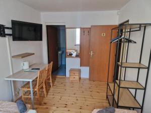 a kitchen and dining room with a table and a desk at Penzion Kornout in Bílina