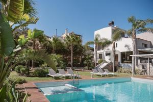 a swimming pool with lounge chairs and a house at Villa Anemeli - Luxury pool villa with gorgeous seaview in Kissamos