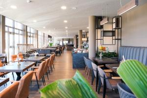 a dining room with tables and chairs in a restaurant at Tools Hotel Laichingen in Laichingen