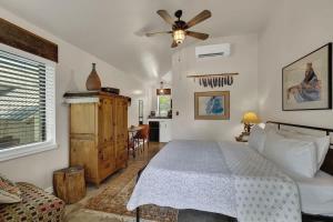 Un dormitorio con una cama y un ventilador de techo. en Chic Comfort Just Steps from Main Street!, en Fredericksburg