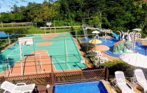 a swimming pool with a slide and a playground at Hotel Bosques do Massaguaçu in Caraguatatuba