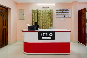a hotel lobby with a red and white reception desk at Super Hotel O GT Road Nellore in Nellore
