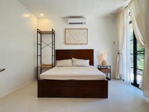 a bedroom with a bed with a wooden head board at Maquiling Resthouse in Los Baños +44 photos