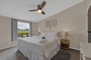 a white bedroom with a large bed and a window at Sage: Peaceful Hill Country Retreat with Hot-Tub! in Morris Ranch +33 photos