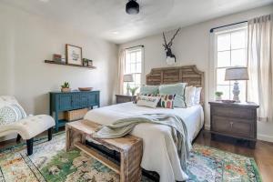 a bedroom with a bed and a chair and windows at Southern Charm - Near Main With Hot Tub in Fredericksburg