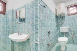 a blue tiled bathroom with a toilet and a sink at Hotel O Hari Singh High Street Formerly City Star in Jawāharnagar