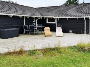 a patio with a table and chairs on it at Luxury Spa Retreat by Sea - By Traum Ferienwohnungen in Trudslev