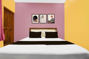 a bedroom with a bed with purple and yellow walls at Super Hotel O Amhat Sultanpur City in Sultānpur +30 photos