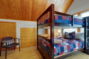 a bedroom with a bunk bed and a chair at Gettin' Guada loopy with Hot Tub & Riverfront in Schumannsville