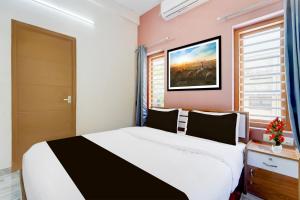 a bedroom with a black and white bed and a window at Super Collection O Westhill Near Govt Engg College in Calicut