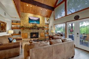 a living room with couches and a stone fireplace at Gettin' Guada loopy with Hot Tub & Riverfront in Schumannsville