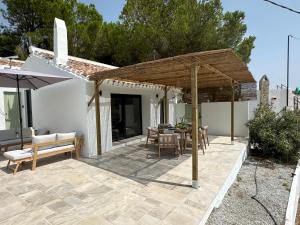 a patio with a wooden umbrella and a table at Finca Celia Competa in Cómpeta