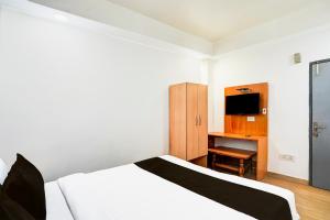 a bedroom with a white bed and a television at Super Collection O Vasundhara Enclave Delhi in Noida