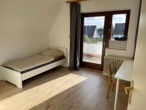 a bedroom with a bed and a door to a balcony at MZ Apartments in Niestetal +4 photos