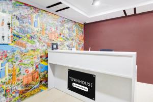 une peinture murale d'une maison de ville sur un mur dans une pièce dans l'établissement Super Townhouse Townvilla Guesthouse, à Ameerpet 23 autres photos