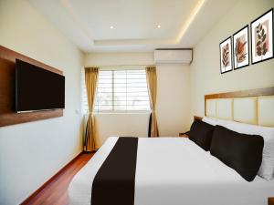 バンガロールにあるSuper Townhouse Ramamurthy Nagar West Formerly Phoenix Hotelのベッドと薄型テレビのある寝室