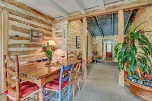 une salle à manger avec une table et des chaises en bois dans l'établissement Historic Log Cabin Retreat Near Town on 5 Acres!, à Fredericksburg