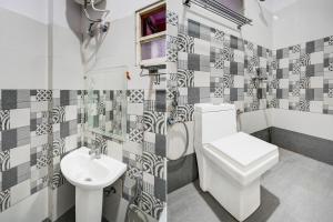 a bathroom with a toilet and a sink at Townhouse Faizabad Road Opp BBD University in Lucknow +42 photos