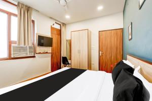 une chambre d'hôtel avec un lit et une télévision dans l'établissement Super Collection O Palam Near Railway Station, à New Delhi