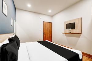 une chambre avec un lit et une télévision au mur dans l'établissement Super Collection O Palam Near Railway Station, à New Delhi