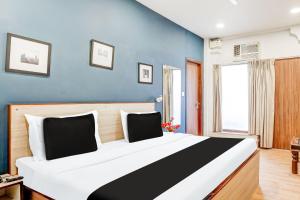 une chambre avec un grand lit avec un mur bleu dans l'établissement Super Collection O Palam Near Railway Station, à New Delhi 23 autres photos