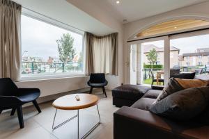 a living room with a couch and a table at Cosy Cottage Apostroff in Koksijde