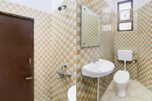 a bathroom with a sink and a toilet and a mirror at Super Hotel O Insaf Nagar Munshipuliya Formerly Vibrant in Lucknow