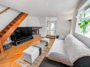 a living room with a couch and a television at Maison conviviale - Proche aéroport Roissy in Le Blanc-Mesnil