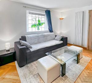 a living room with a couch and a glass table at Maison conviviale - Proche aéroport Roissy in Le Blanc-Mesnil +25 photos