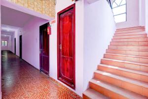 a red door on the side of a building with stairs at Hotel O Nemeli Road Sriram Nagar in Chennai