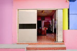 an open doorway to a pink building with a door at Hotel O Nemeli Road Sriram Nagar in Chennai