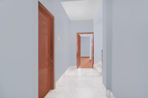 a hallway with white walls and an open door at Super Collection O SRS Residency in Shillong