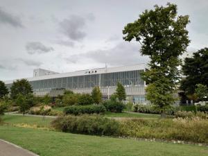 a large white building with a tree in front of it at HOTEL TETORA ASAHIKAWA EKIMAE - Vacation STAY 91488v in Asahikawa