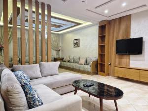 a living room with a couch and a tv at Residence Niama C in Tetouan