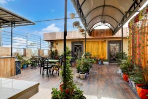 an indoor patio with tables and potted plants at Super Townhouse Hyderabad Gate IIT BHU Formerly RK Heights in Varanasi +32 photos