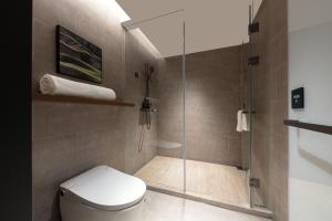Atour Hotel Wujiaochang QuyangBailian ShoppingMall Shanghai في شانغهاي: حمام مزود بمرحاض ودش زجاجي