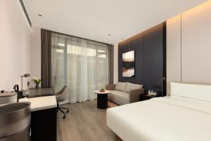 Atour Hotel Wujiaochang QuyangBailian ShoppingMall Shanghai في شانغهاي: غرفة فندق بها سرير ومكتب
