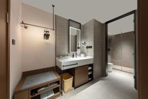 Atour Hotel Wujiaochang QuyangBailian ShoppingMall Shanghai في شانغهاي: حمام مزود بحوض ومِرآة