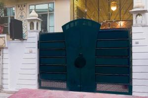 a blue gate in front of a building at Super Hotel O Sikar Road Jaipur Formerly Garg Niwas in Jaipur +41 photos