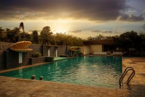 インドールにあるHotel Solarisの夕日が沈むリゾートのプール